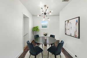 Dining area featuring dark wood-style floors (Virtually Staged)