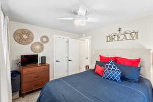 Carpeted bedroom featuring ceiling fan