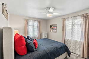 Carpeted bedroom featuring ceiling fan