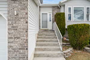 Entrance to property featuring a garage and brick siding