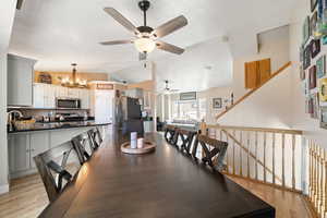 Dining space with a chandelier, lofted ceiling, and light wood finished floors