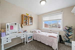 Bedroom featuring dark colored carpet and a textured ceiling