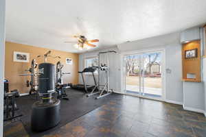 Workout room featuring a textured ceiling, visible vents, and baseboards