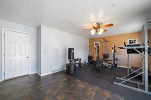 Workout room with baseboards, visible vents, ceiling fan, and a textured ceiling