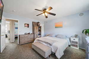 Bedroom with a ceiling fan, dark colored carpet, a textured ceiling, and baseboards