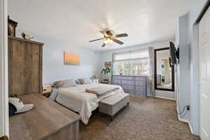 Bedroom with a ceiling fan, carpet flooring, a textured ceiling, and baseboards