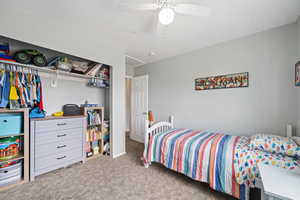 Bedroom with ceiling fan and light colored carpet