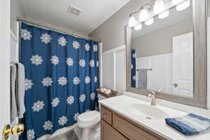 Full bathroom featuring a textured ceiling, toilet, vanity, and visible vents