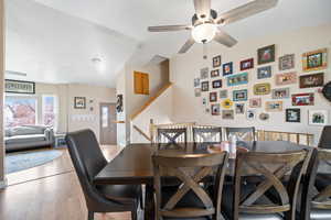 Dining area with a ceiling fan and light wood-style flooring