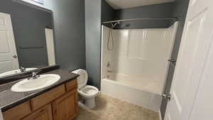 Bathroom featuring toilet, vanity, washtub / shower combination, and tile patterned floors