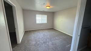 Unfurnished bedroom with carpet flooring and baseboards