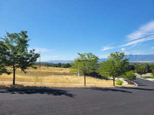 View of asphalt street with a mountain view, curbs, and a view of countryside