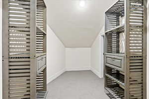 Spacious Master Bedroom closet featuring lofted ceiling and light colored carpet