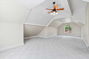 "OTG" Bonus room with lofted ceiling, ceiling fan, light carpet, and baseboards