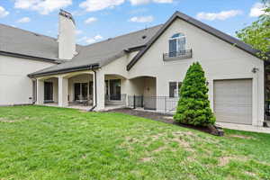 Rear view of property with a yard, a patio, a chimney, stucco siding, and a shingled roof