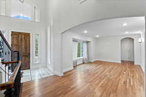 Foyer entrance featuring light wood-style floors, arched walkways, and ornamental molding