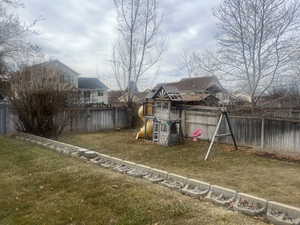 View of jungle gym featuring a yard and a fenced backyard