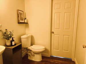 Half bath featuring toilet and wood finished floors