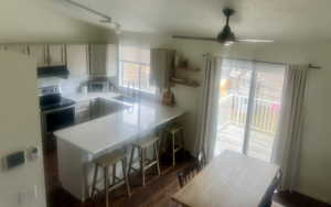 Kitchen featuring electric stove, dark wood-style flooring, light countertops, white cabinetry, and a sink