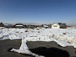 Yard layered in snow with a mountain view