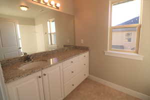 Bathroom with visible vents, baseboards, and vanity