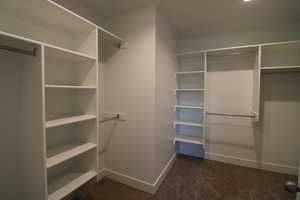 Walk in closet with dark colored carpet