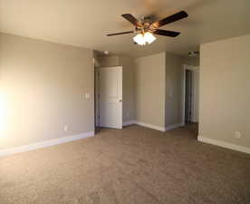 Unfurnished room featuring carpet, a ceiling fan, and baseboards