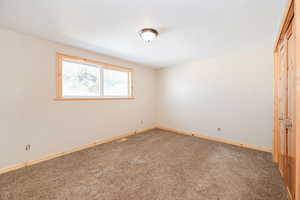 Carpeted spare room with a textured ceiling, visible vents, and baseboards