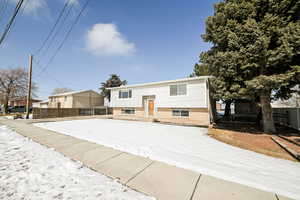 Split foyer home featuring fence and brick siding