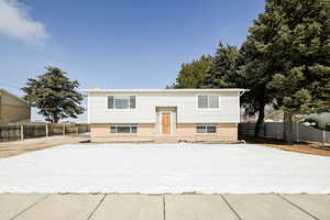 Split foyer home with brick siding and fence