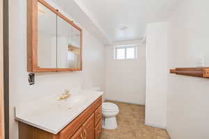 Full bath featuring toilet, tile patterned flooring, baseboards, and vanity