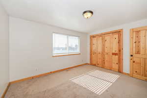 Unfurnished bedroom featuring light colored carpet, visible vents, baseboards, and a textured ceiling