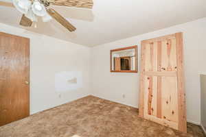 Carpeted empty room featuring ceiling fan and a textured ceiling