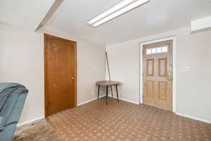 Foyer entrance with baseboards, a textured ceiling, and tile patterned floors