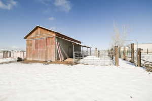 Snow covered structure featuring an exterior structure and an outbuilding