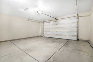 Garage with baseboards and a garage door opener