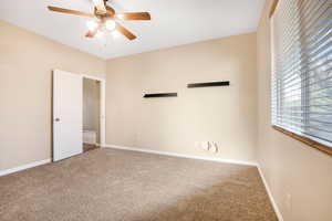 Unfurnished room featuring a ceiling fan, carpet flooring, and baseboards