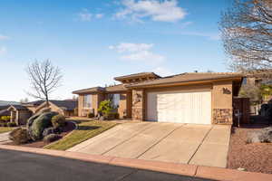 Prairie-style home featuring a tile roof, stucco siding, concrete driveway, an attached garage, and stone siding