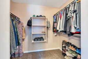 Walk in closet with carpet floors