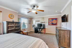 Bedroom featuring ornamental molding, a ceiling fan, light carpet, a textured ceiling, and baseboards