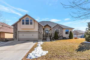 View of front of home featuring a garage, a shingled roof, concrete driveway, a front yard, and stucco siding