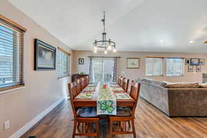 Dining area with lofted ceiling, plenty of natural light, and wood finished floors