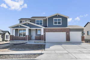 View of front of home featuring concrete driveway, an attached garage, and brick siding