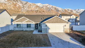 View of front of property featuring an attached garage, driveway, fence, and a mountain view