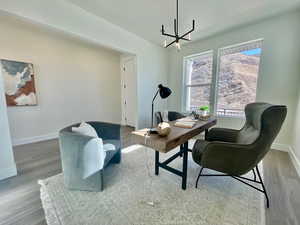 Office area with an inviting chandelier, baseboards, and wood finished floors