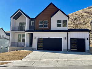 Modern farmhouse style home with a garage, board and batten siding, and concrete driveway