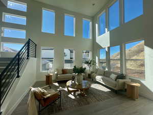 Living area featuring a mountain view, stairway, baseboards, and wood finished floors