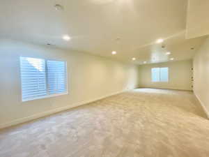 Spare room with recessed lighting, light carpet, visible vents, and baseboards