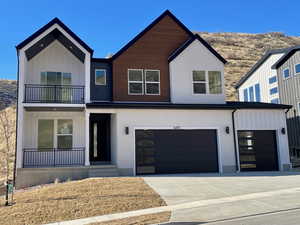 View of front of home featuring board and batten siding, a garage, and concrete driveway