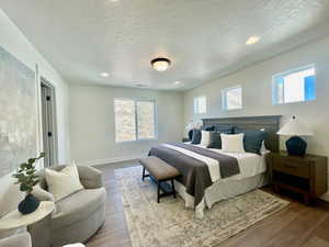 Bedroom featuring a textured ceiling, recessed lighting, wood finished floors, and baseboards